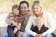 Photo: Family sitting on beach smiling Family sitting on beach smiling