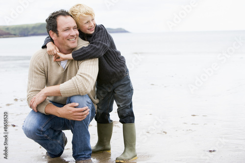 Photo: Father and son at beach smiling Father and son at beach smiling