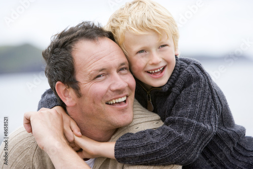 Photo: Father and son at beach smiling Father and son at beach smiling