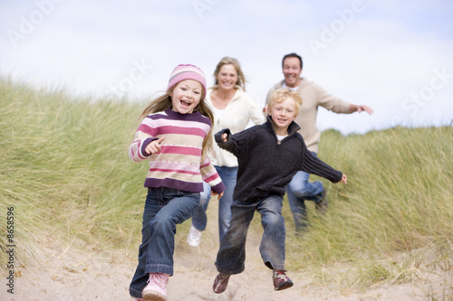 Photo: Family running on beach smiling Family running on beach smiling