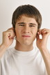 Young male adult holding ears
