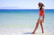Young woman on beach with her feet in water