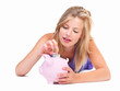 Young girl putting notes into a piggy bank Young girl putting notes into a piggy bank