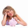 Young woman putting notes into a piggy bank Young woman putting notes into a piggy bank