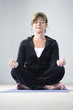 Portrait of a mature woman sitting in lotus position.