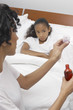 Nurse pouring medication for girl 7-9 lying in bed