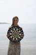 Businesswoman on beach with dartboard