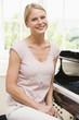 Woman sitting at piano and smiling Woman sitting at piano and smiling