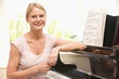 Woman sitting at piano and smiling Woman sitting at piano and smiling