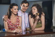 Two women and man in a bar