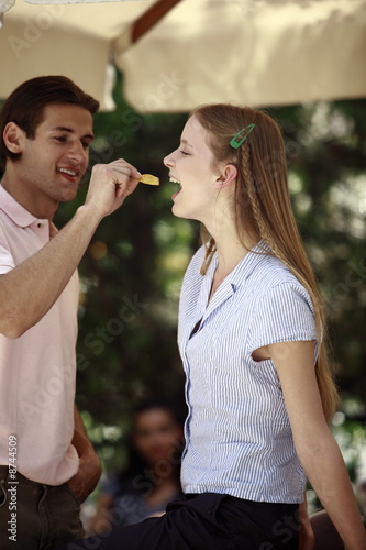 Photo: Man feeding woman a potato chip Man feeding woman a potato chip