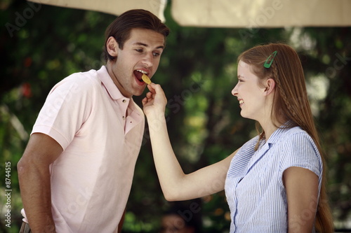 Foto: Woman feeding man a potato chip Woman feeding man a potato chip