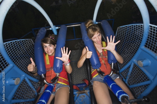 Photo: Two female teenagers on amusement park ride Two female teenagers on amusement park ride