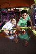 Teenage couple playing game in arcade