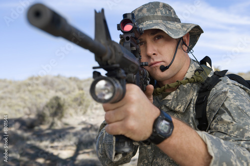 Foto: Soldier aiming machine gun, close-up Soldier aiming machine gun, close-up