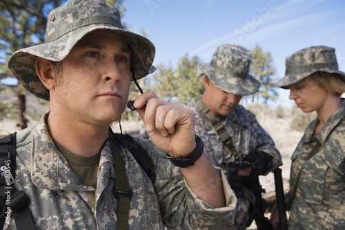 Photo: Soldiers in field, focus on one in foreground Soldiers in field, focus on one in foreground
