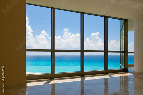 View of tropical beach through hotel windows