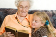 Photo: uroma und urenkel sehen zusammen ein buch an uroma und urenkel sehen zusammen ein buch an