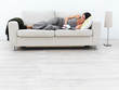 Casual young lady lying on sofa reading book,at home