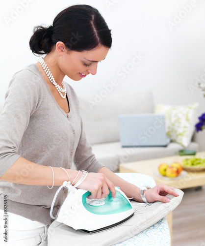 Portrait of a happy young lady ironing her clothes Portrait of a happy young lady ironing her clothes