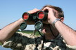 Male field officer watching thru binocular Male field officer watching thru binocular