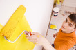 Young man paints a wall in a new house