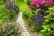 Lush blooming summer garden with paved path Lush blooming summer garden with paved path