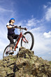 Girl rides a bike in mountains.