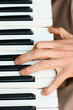 hands playing music on the piano, keyboard