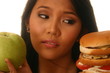 Woman choosing burger and apple