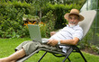 senior  in garden at leisure with laptop computer