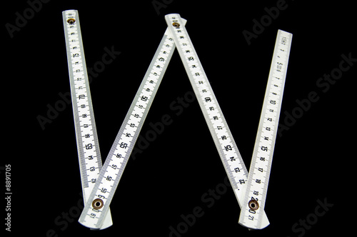 open white folding rule "W" shaped on black background open white folding rule "W" shaped on black background