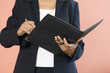 Foto: Midsection of a business woman writing in a file. Midsection of a business woman writing in a file.