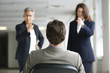 Two businesswomen interrogating a man.