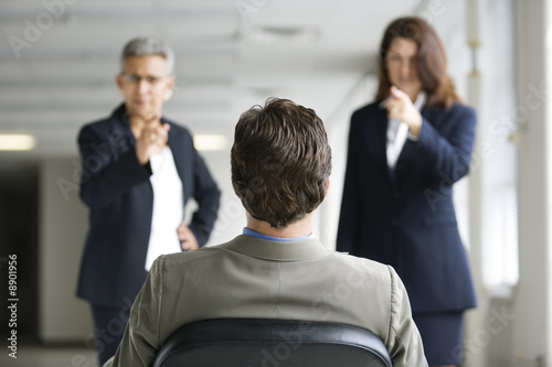 Photo: Two businesswomen interrogating a man. Two businesswomen interrogating a man.