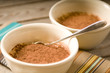 Tiramisu with a spoon on a wooden table with a colorful placemat