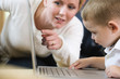 View of a mother teaching her son to use the computer.