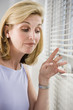 Foto: A business woman looking out from a window. A business woman looking out from a window.