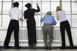 Foto: Business executives looking through blinds. Business executives looking through blinds.