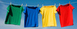 a set of primary colored T-shirts hanging on a clothesline