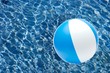 Striped beach ball over the water surface