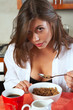 Sexy young adult brunette woman in black lingerie eating
