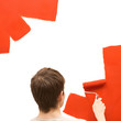Man painting wall with red roller