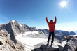 Sign of victory: climber on the top of the mountain
