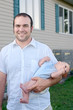 A father with his baby son hanging over his arm