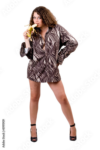 Photo: young sexy beauty woman in a man's shirt with a banana. Isolated young sexy beauty woman in a man's shirt with a banana. Isolated