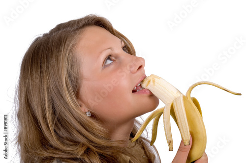 Photo: Portrait of the young woman with a banana. Isolated Portrait of the young woman with a banana. Isolated