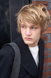 Teenage boy looking over shoulder outside building