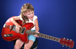 little girl playing with red electric guitar and singing