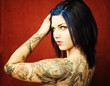 Pretty young woman with many tattoos on her back and arms Pretty young woman with many tattoos on her back and arms